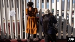 Asylum seekers wait for news on immigration appointments at the El Chaparral crossing port in Mexico on January 21.