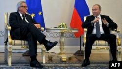 Russian President Vladimir Putin (right) meets with European Commission President Jean-Claude Juncker in St. Petersburg on June 16. The policy document leaves an opening for improved relations between Brussels and Moscow, stating that "the EU and Russia are interdependent."