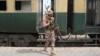 A Pakistan Army soldier stands guard next to a rescue train at the railway station in Mushkaf, Balochistan, on March 12 after an attack by separatist militants the day before. 