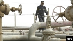 An Iraqi security guard walks along a pipeline at a refinery near the Umm Qasr port in the southern city of Basra.